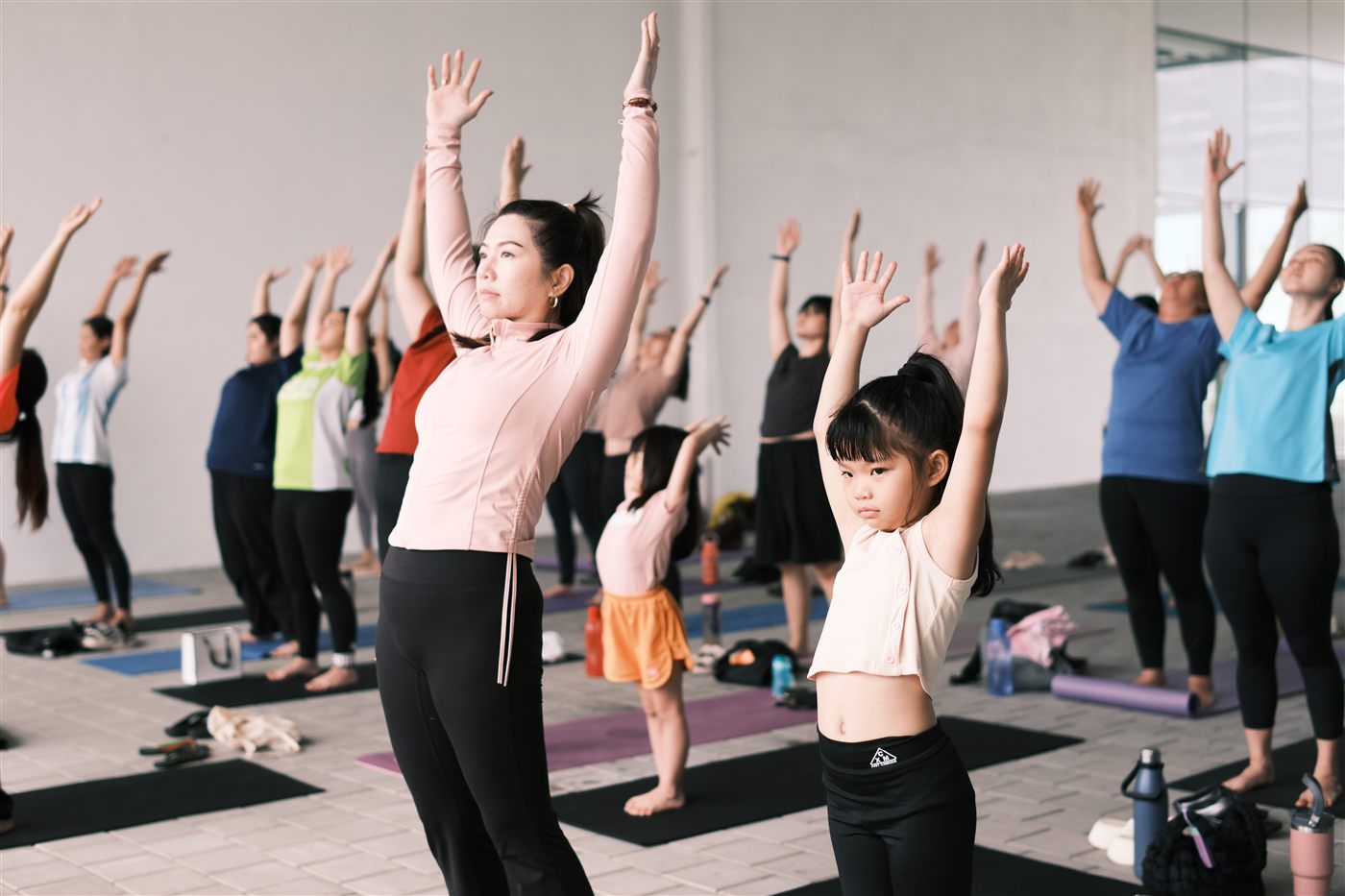 Mothers and daughters practising yoga together